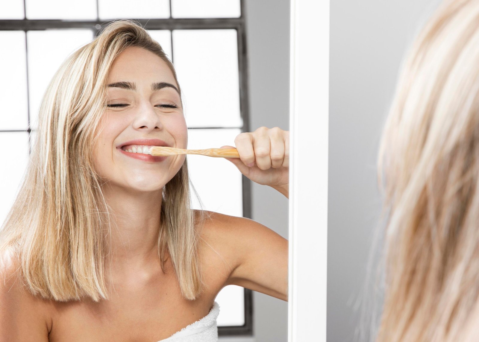 A woman brushing her teeth, reflecting a healthy routine for at-home teeth whitening in Woodland Hills.